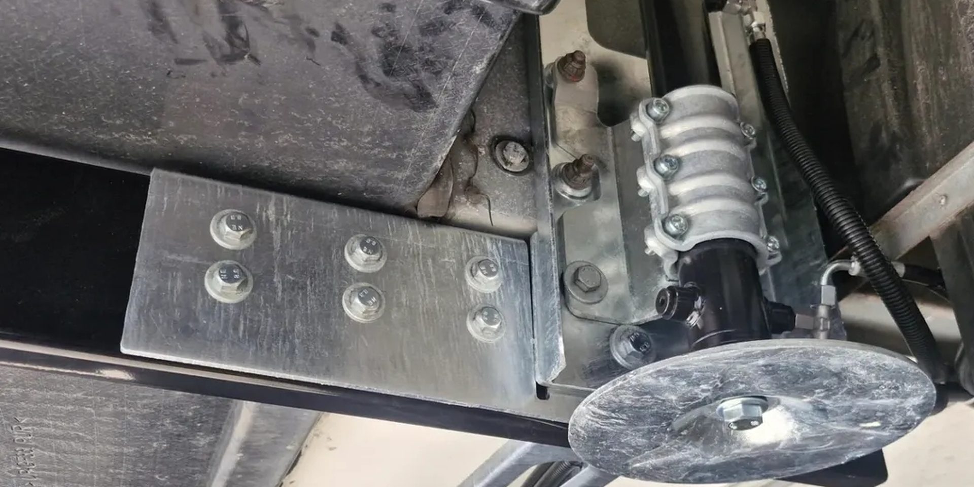 Stempel van een levelsysteem, met verzinkte beugels vastgebout aan het chassis van een camper