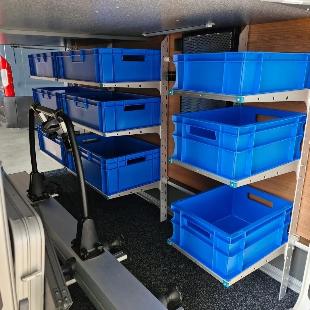 Twee YouRS-wanden met blauwe Euroboxen in de garage van een camper, gemonteerd door Mees Outdoor